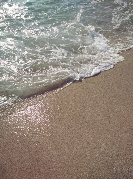 a surfboard laying on top of a sandy beach