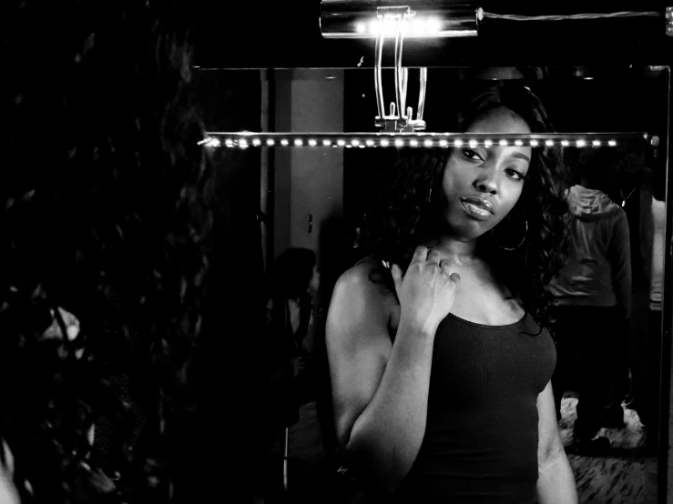 a woman is standing in front of a mirror looking at her reflection