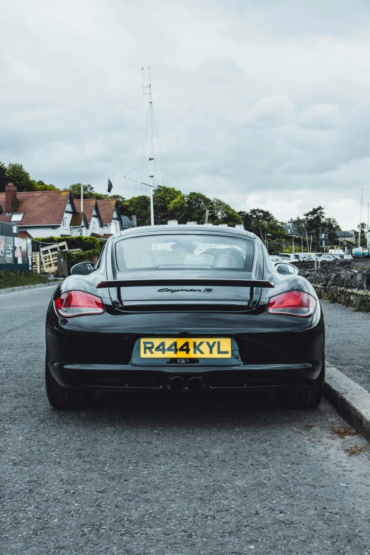 a porsche car parked on the road with a small boat in the back