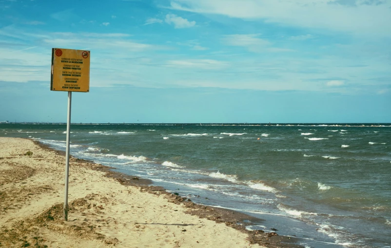 an outdoor beach is shown with sign