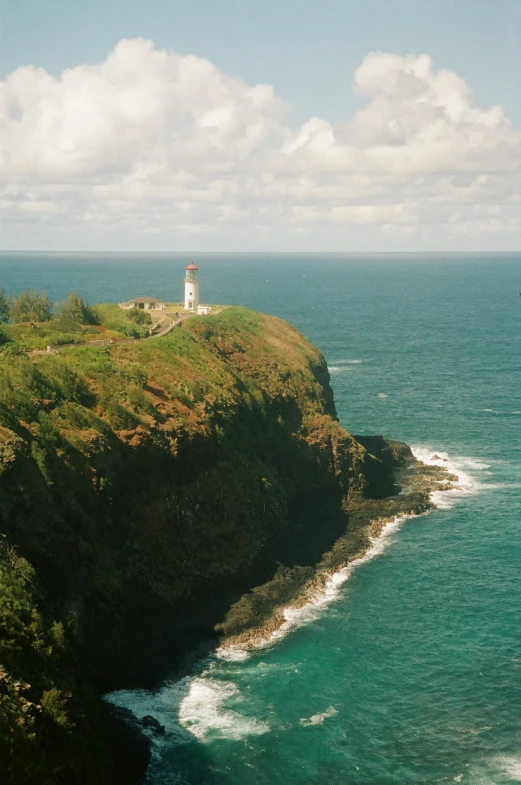 a lighthouse near the ocean with a sky background