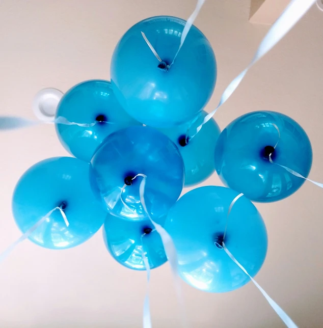 a bunch of blue balloons floating from a ceiling