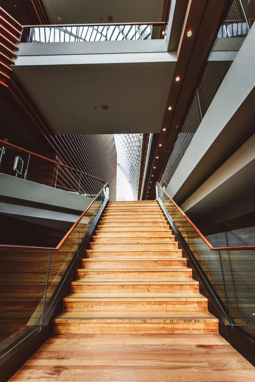 a staircase leading to two floors with wood hand rails