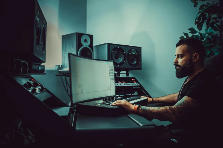 a man sits at a desk in front of several monitors