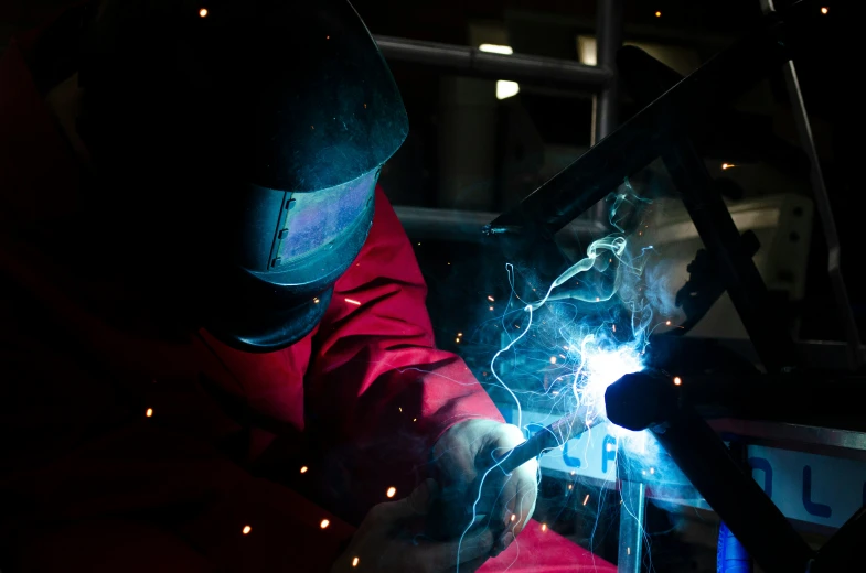 a welder working with an arc welding machine in the dark