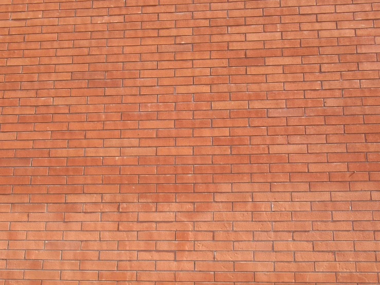 a fire hydrant is standing by a brick wall