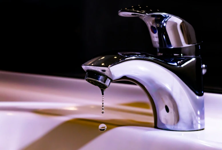 a faucet pouring water on a white sink