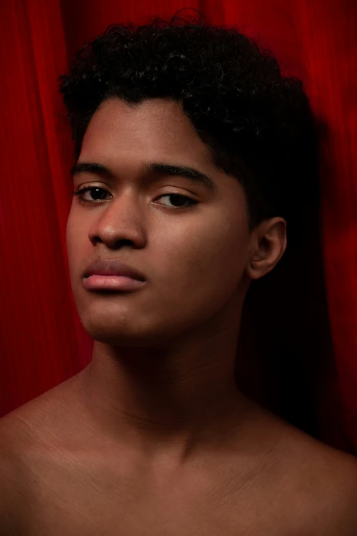 a man is posing in front of a curtain