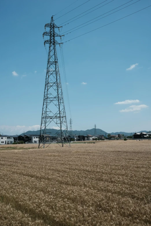 an industrial electric tower near a farm land