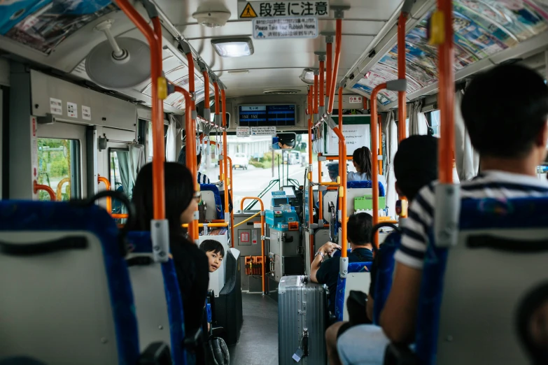 people with luggage inside a bus, one has an open door