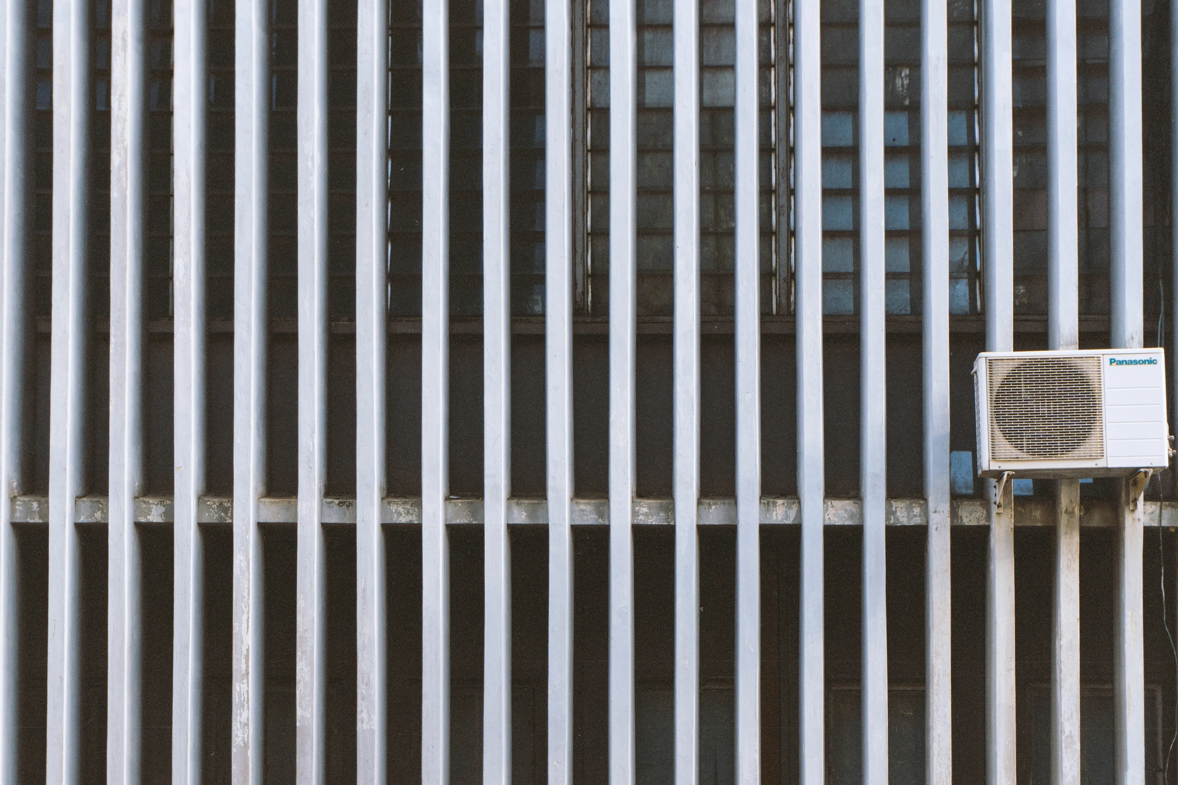 a air conditioner sitting next to a metal wall