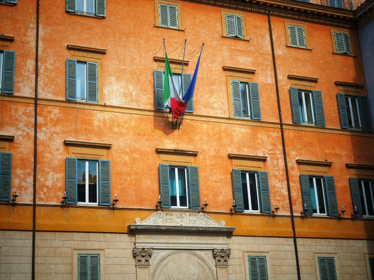 an orange building with shutters and a clock