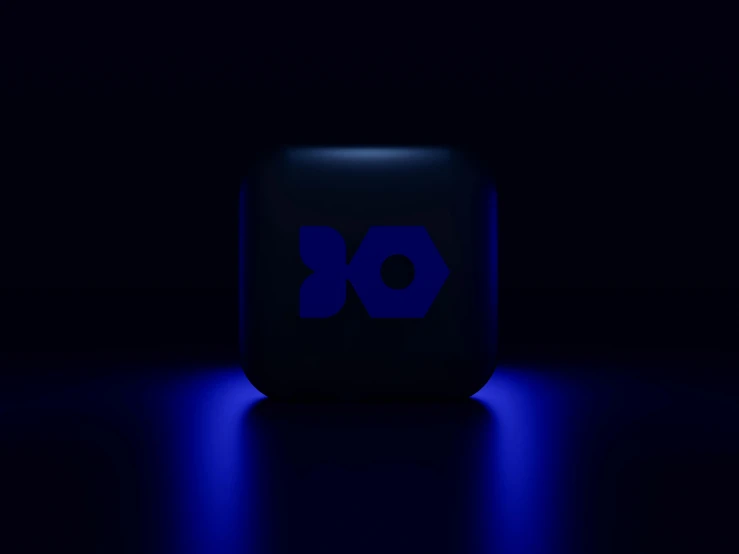a dark room has a glowing blue logo on the back of it