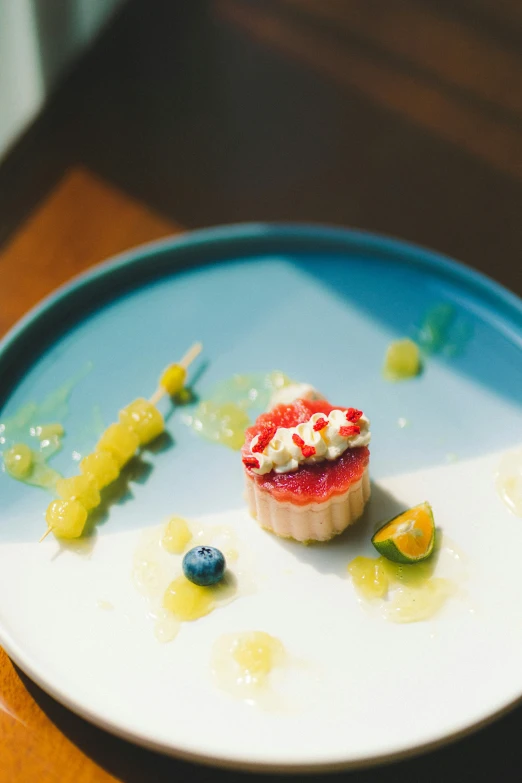 a dessert plate with tiny deserts and fruit on the side