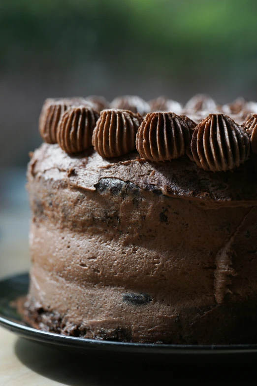 there is a chocolate cake with four heart shaped cookies on it