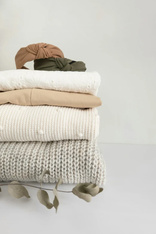 a stack of folded blankets sitting on top of a white table