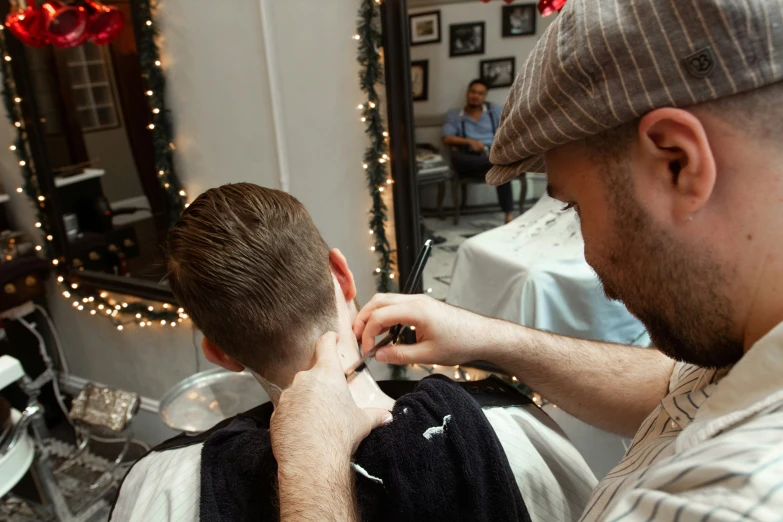 a man getting his hair styled by another person