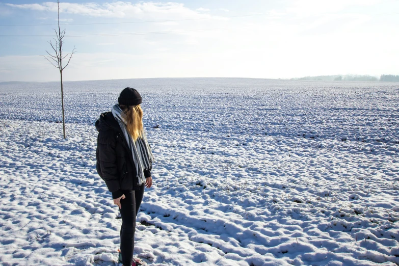 a person standing in the snow with a hat on