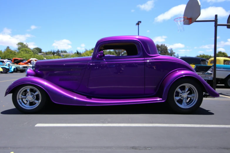 a purple car with black rims in a parking lot