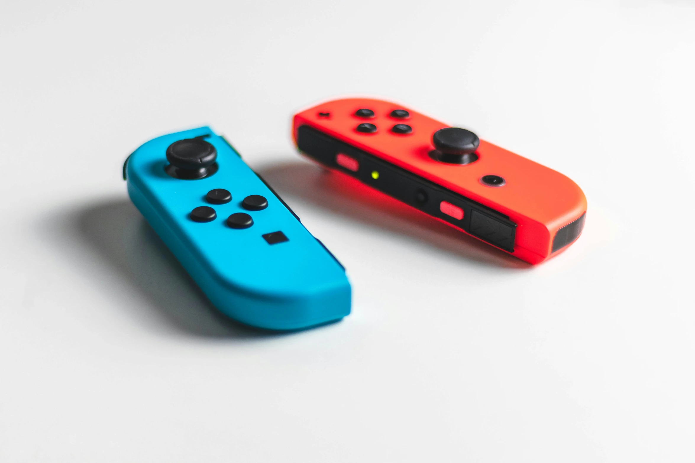 a pair of blue and orange nintendo wii controllers