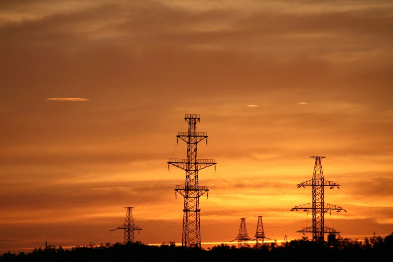 a group of very tall radio towers against a cloudy sky