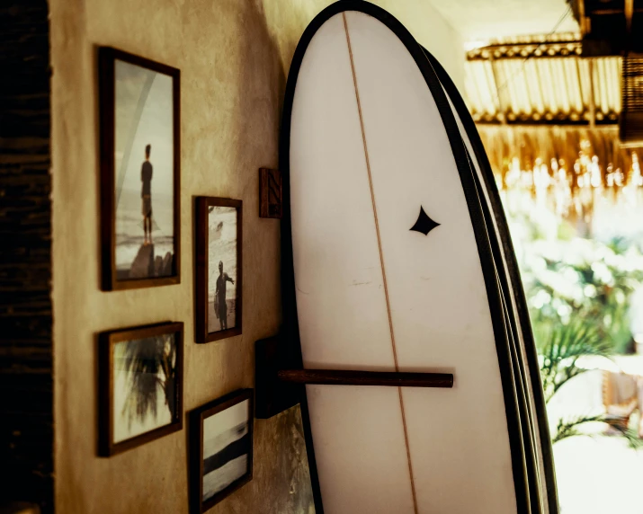 a white surfboard leans up against a wall