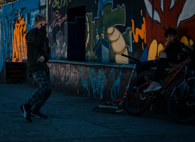 two young men are sitting on their bikes in the dark