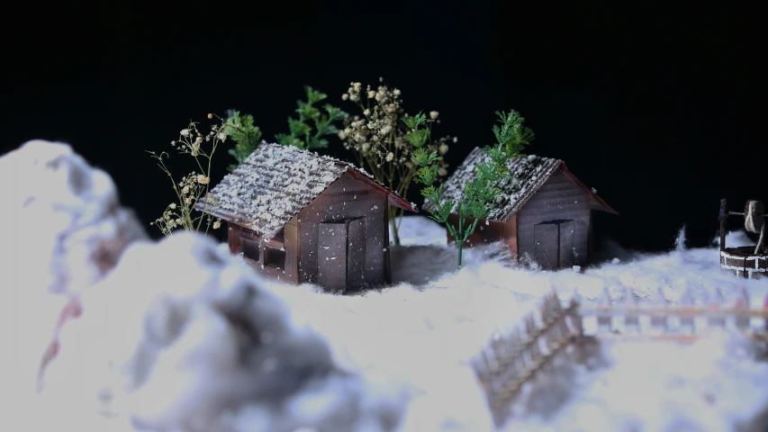 two wooden houses are surrounded by snow and green trees