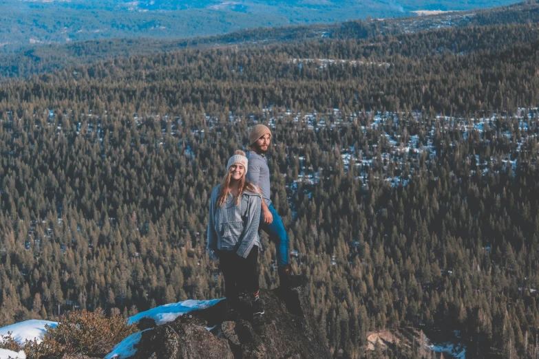 two people stand on top of a hill
