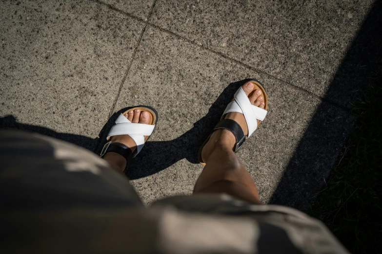 a person sitting with two different sandals