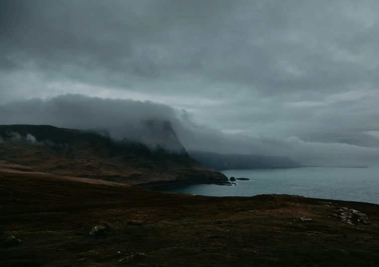 a large lake on a hilly surface during cloudy weather