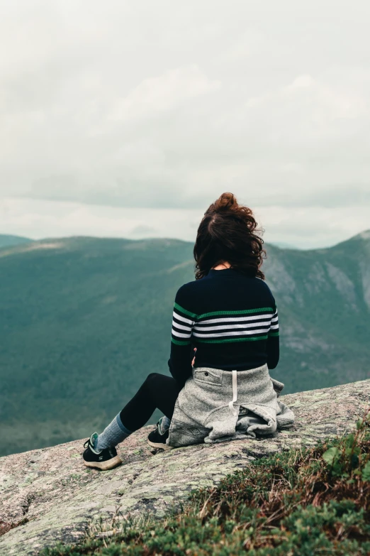 young person looking at scenic mountain valley on cloudy day