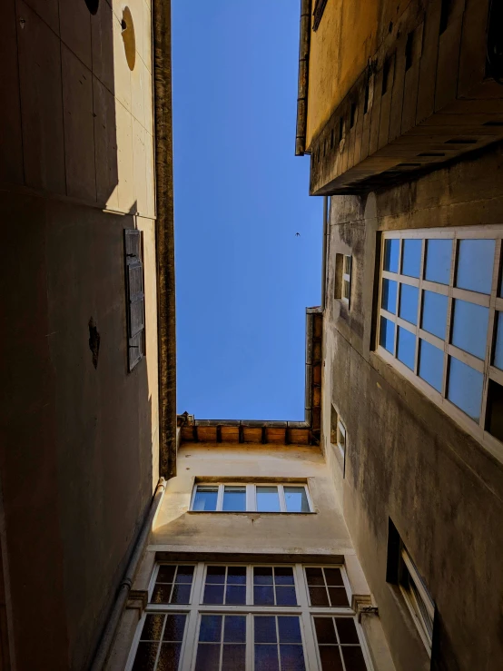 two windows of an old building with blue sky in the background