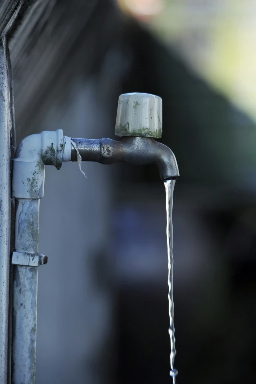 a faucet with water running off it is next to a building