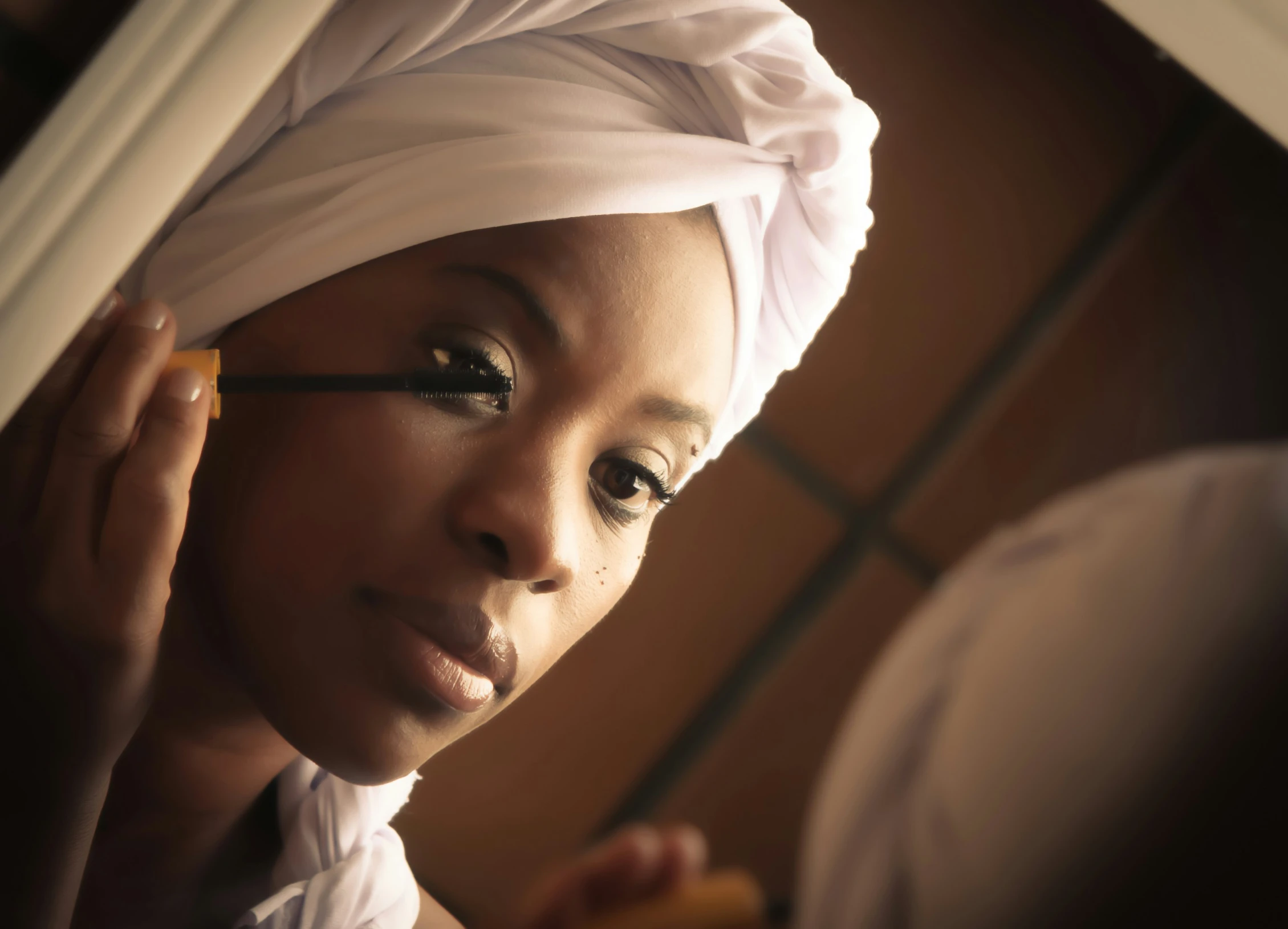 a beautiful young black woman in a turban holding a drink