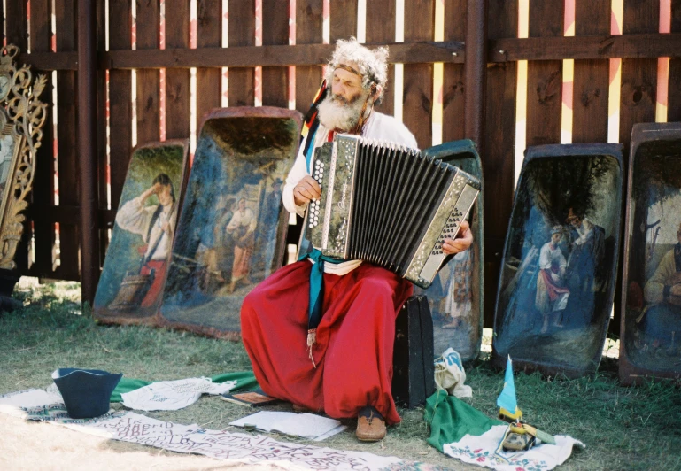 a man with an accordion sitting on the ground