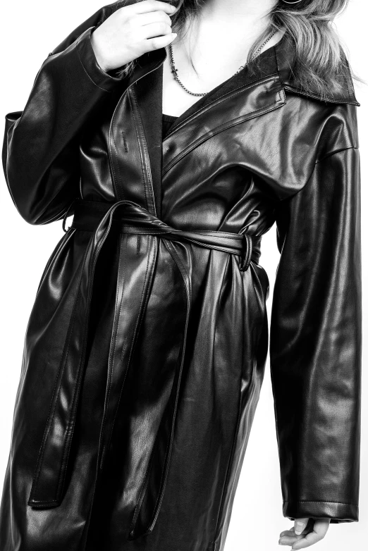 a woman posing in black leather with a long coat