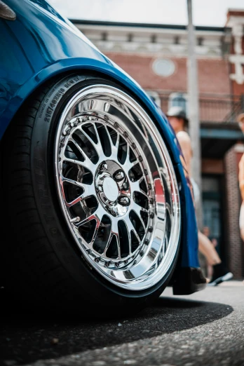 a wheel on a blue sports car in the street