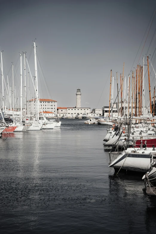 sailboats are moored in the water near a clock tower