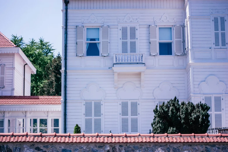 a tall white building with three levels and several windows