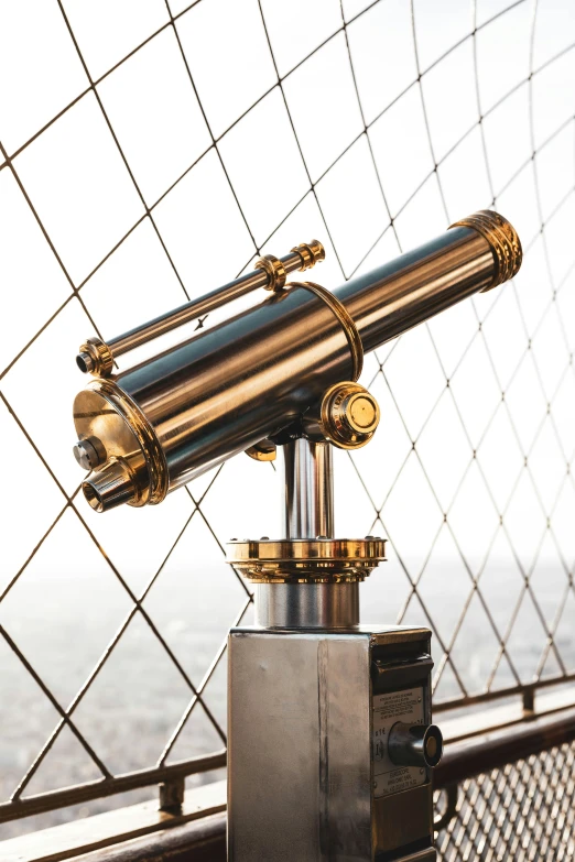 a telescope mounted on a stand on a bridge near the water