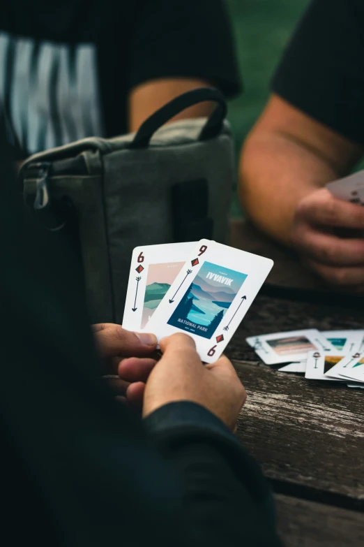a person is holding a card near two cards