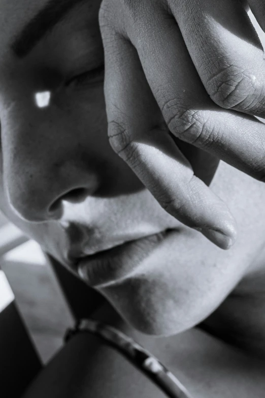 close up image of a woman's face with fingers over the lips