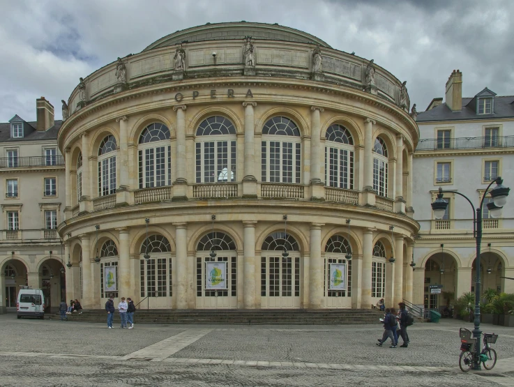 large building sitting on the side of the road with people standing outside it