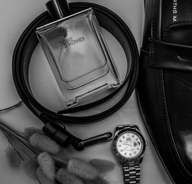 a picture of a watch, some accessories and a leather bag