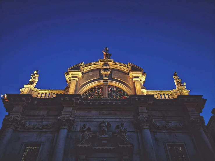 a big building with statues sitting at the top