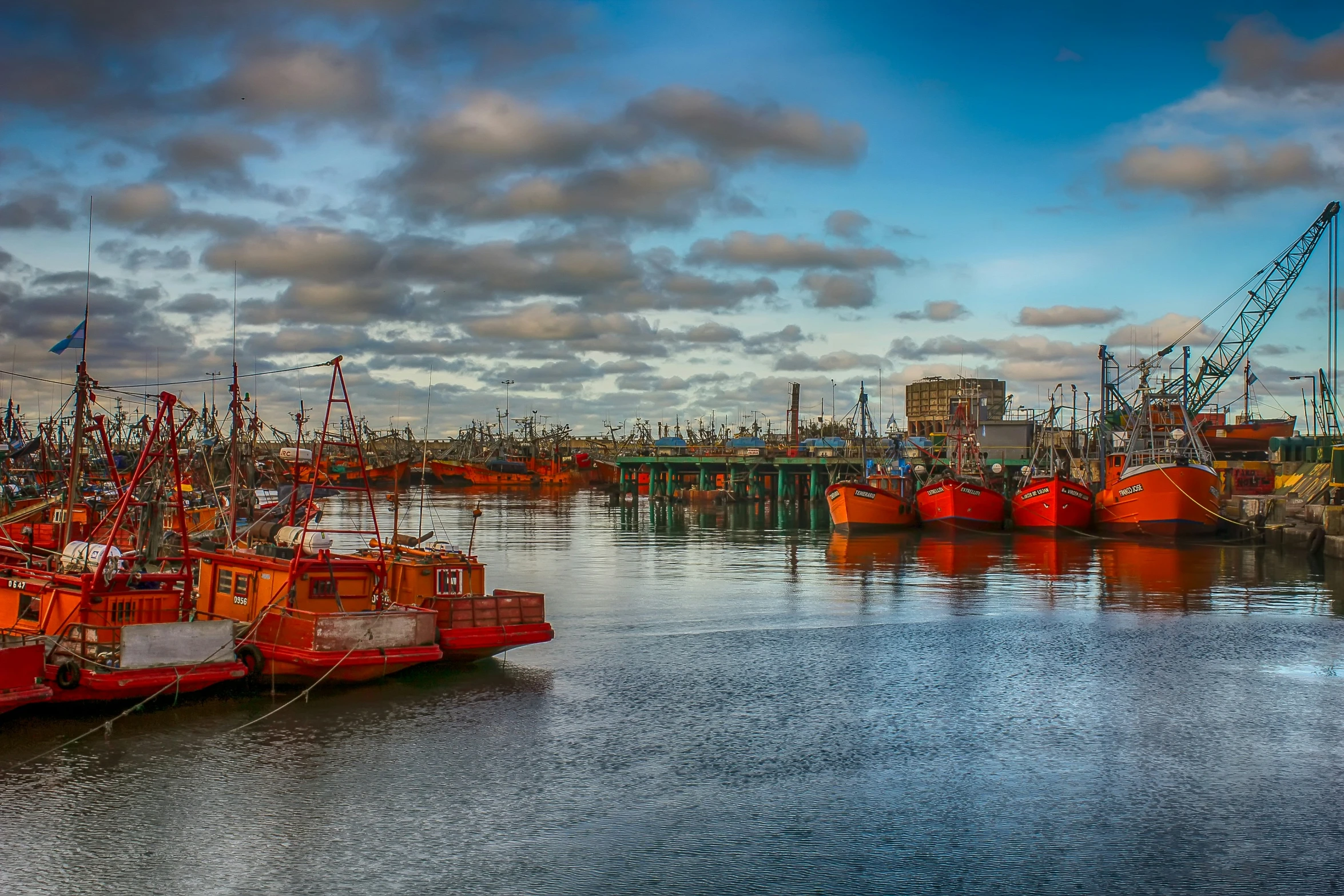 several ships are docked in the harbor next to some pier