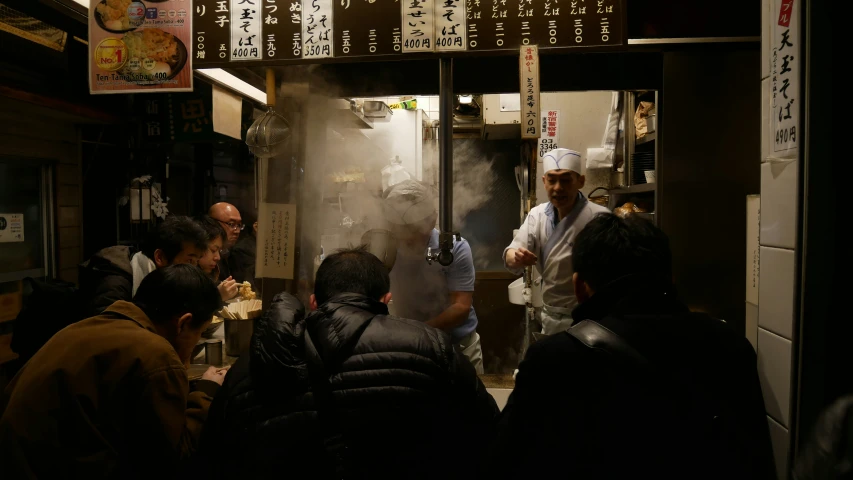 a group of people standing around cooking food