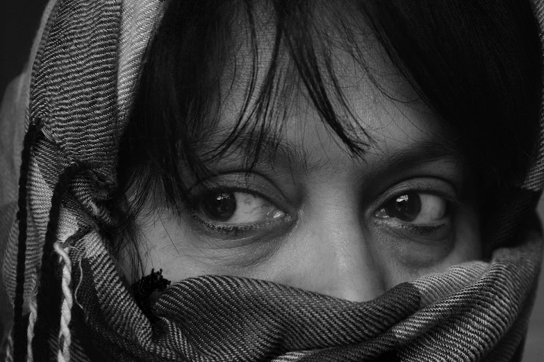 a woman with veils on her face in black and white