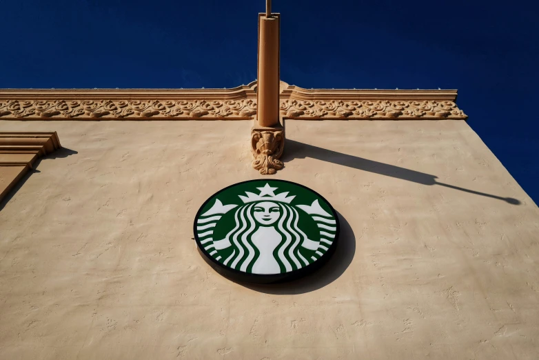 a starbucks logo hanging on the side of a building